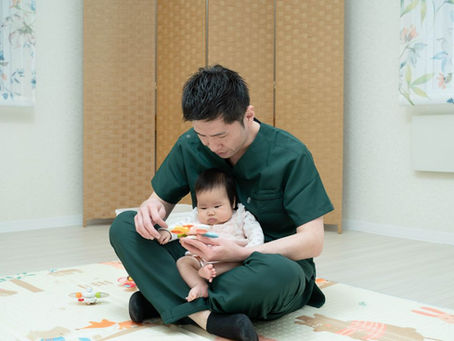 赤ちゃんにやさしく触れながら行うオステオパシー施術の様子