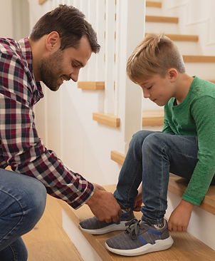 parent tying kids shoes