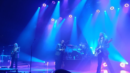 A blue-tinted image of The Aces on stage during a song as their 2023 London show.