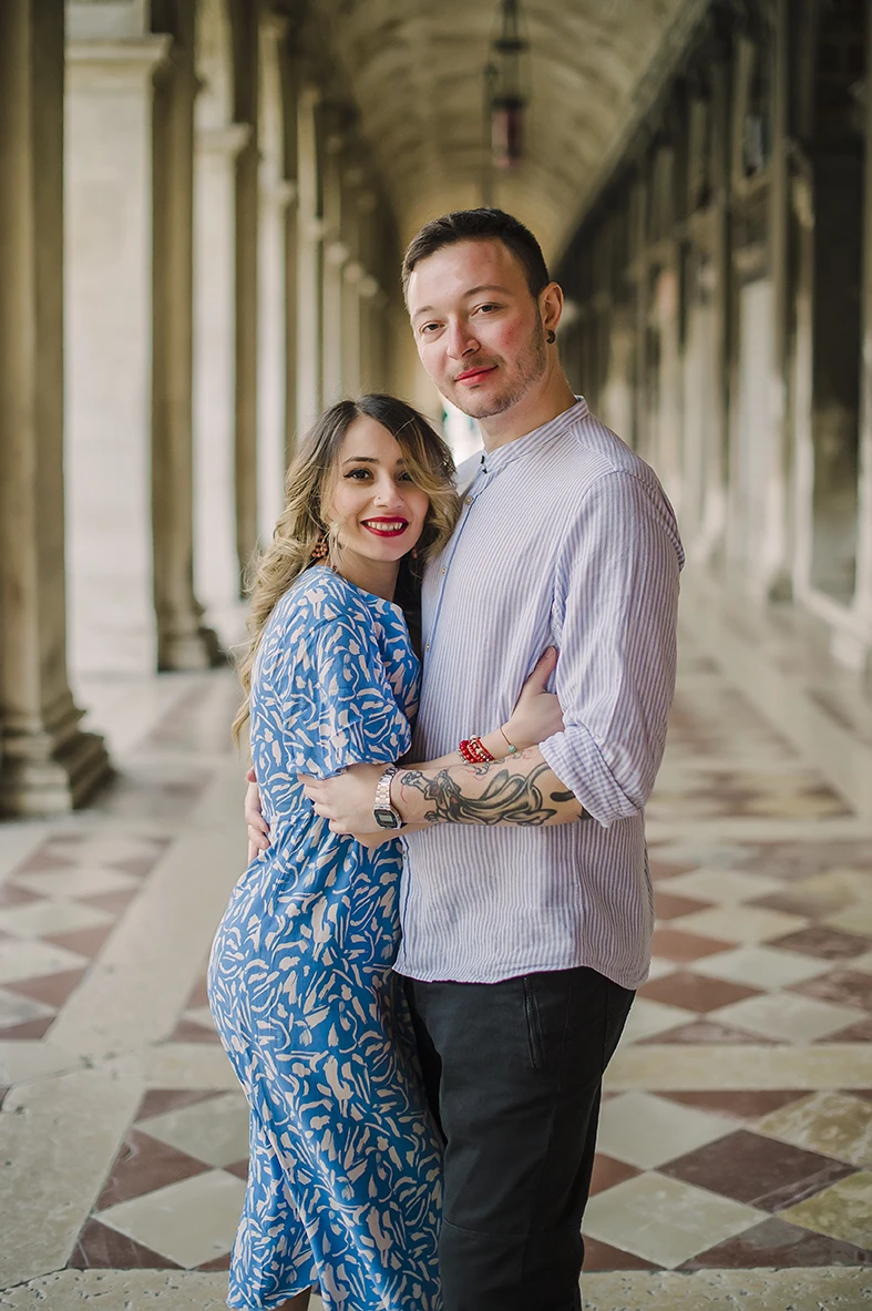 The fiancés share a gentle kiss  with the historic buildings of Venice 