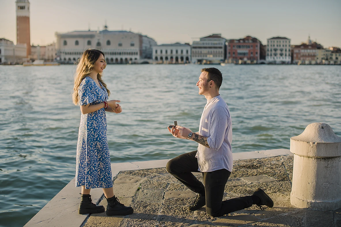Barth unexpectedly gets down on one knee in San Giorgio Maggiore, presenting an engagement ring to a surprised Maria, whose hands cover a joyful smile