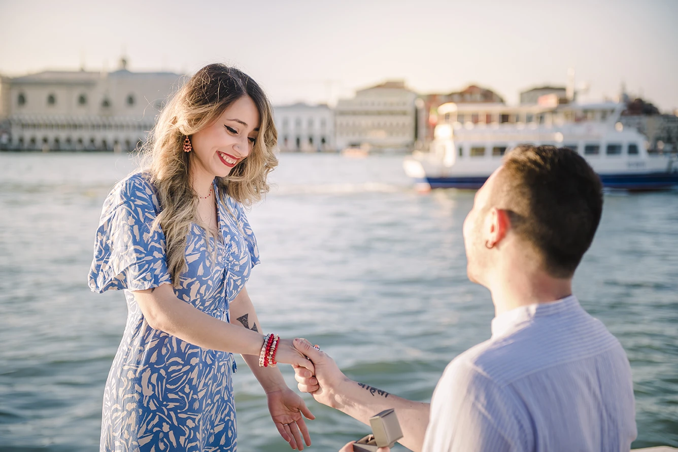 Maria and Barth, hold hands and stare into each other's eyes with affection, the golden hour sunlight softly illuminating their faces.