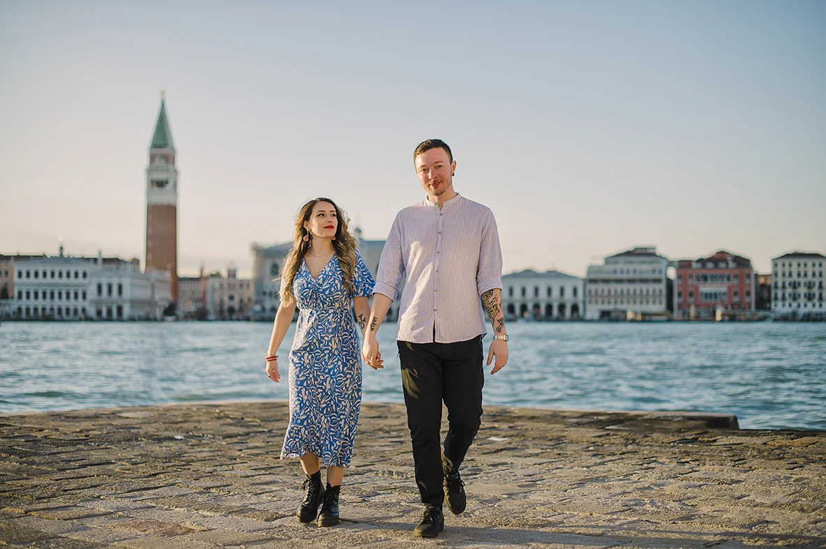 Maria and Barth, hold hands and stare into each other's eyes with affection, the golden hour sunlight softly illuminating their faces.