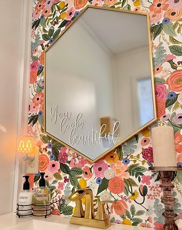 A charming bathroom with bright floral wallpaper covers the walls. 