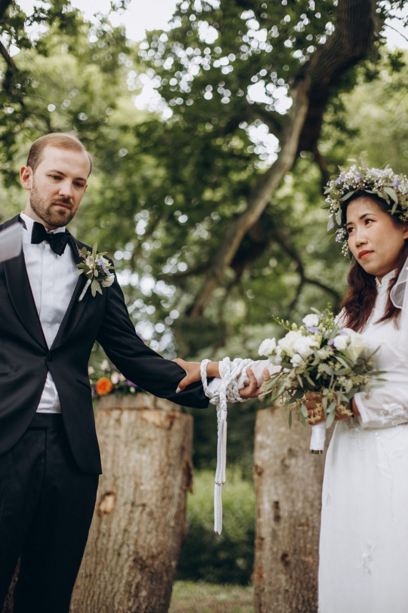 A picture of the couple during handfasting ceremony at their fairytale wedding in the forest