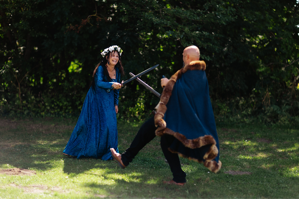 Newlyweds enjoying a playful Viking sword-fighting game during their Viking wedding at Trelleborg in Denmark