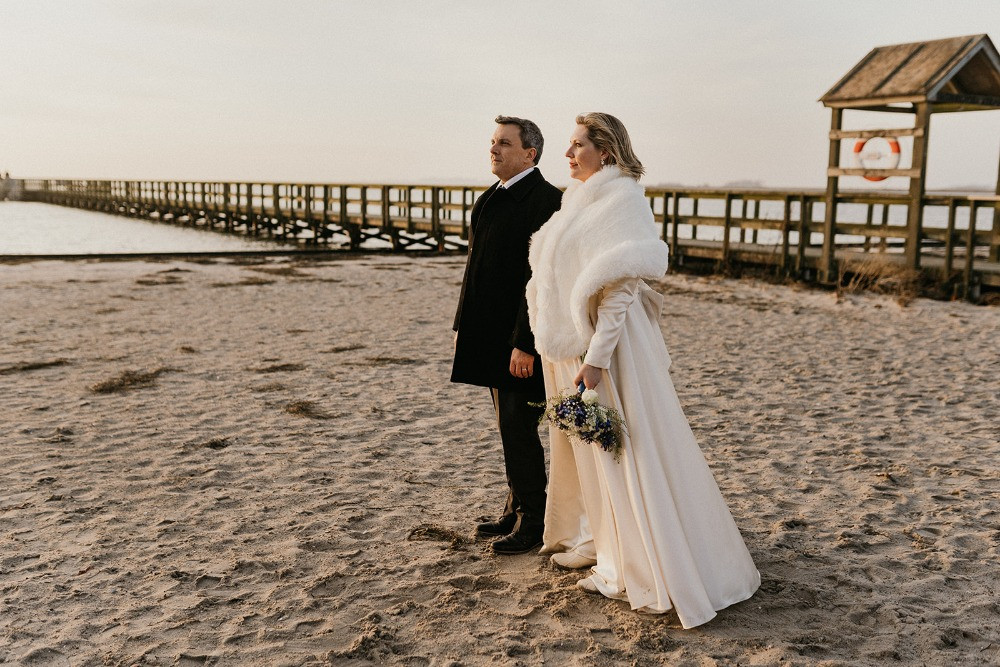 A couple on the beach during their January wedding in Denmark