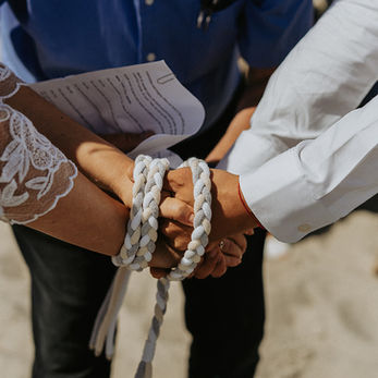 Handfasting ceremony on the beach, symbolizing the joy of marrying abroad in Scandinavia.