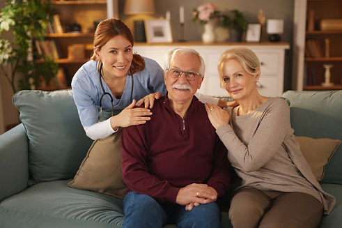 An elderly couple sits on a couch in their living room.jpg