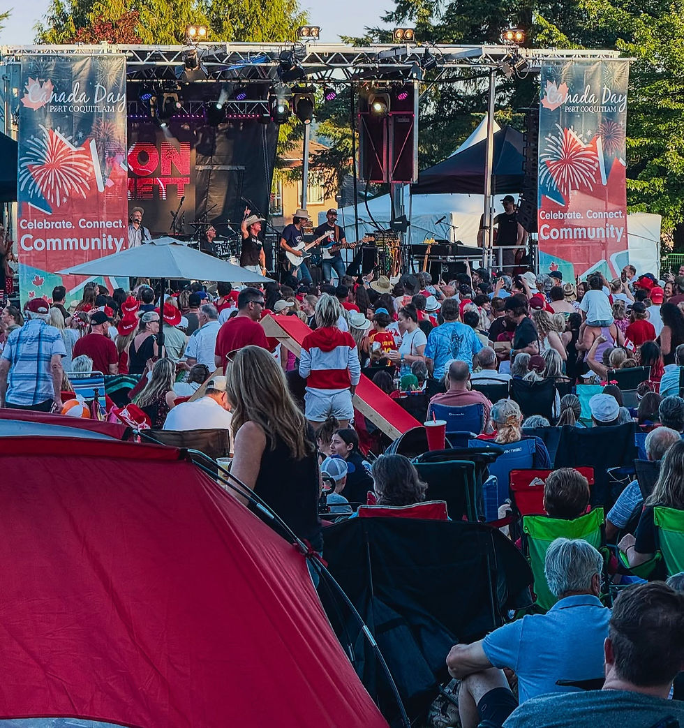 Crowd at a Canada Day festival, with a band playing on stage. Red and white decorations, banners reading "Celebrate. Connect. Community."