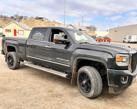 Dark gray GMC Sierra truck with custom decals