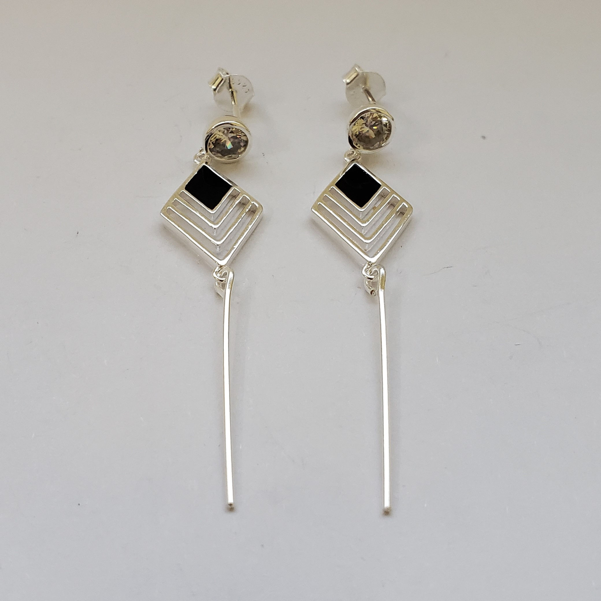 5BR1101 - Brinco losango vazado com onix e base com zircônia