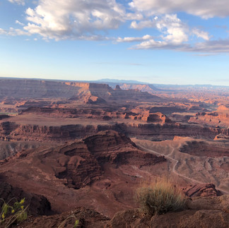 Dead Horse Point State Park. Early morning with a few clouds over red, brown and pick rock formations.