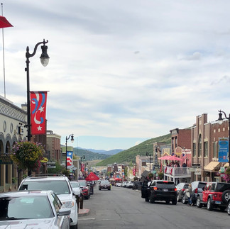 Park City Main Street lined with vehicles, shops and restaurants.