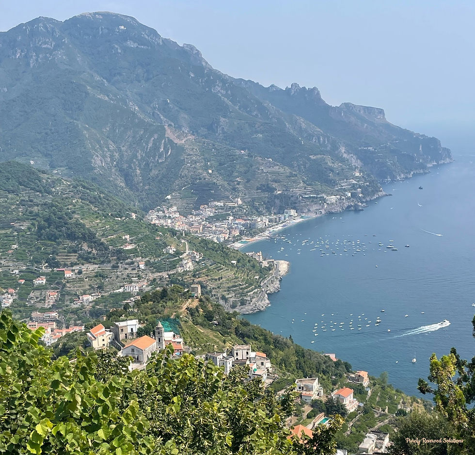 View of the Tyrrhenian Sea from Ravello. Yachts anchored in the water with towns nestled along the coast and mountains.