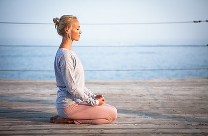 Woman doing mindfulness while sitting with water in the background