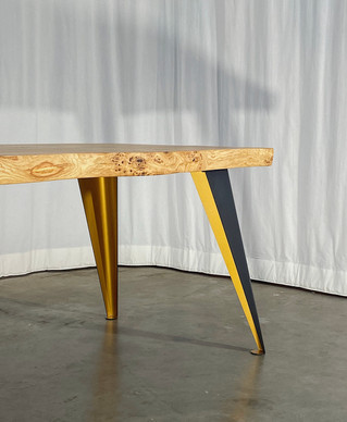 Eiken boomstamtafel met stalen poten en een gouden kleurtint.jpeg
