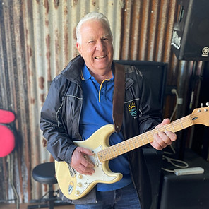 older male holding an electric guitar