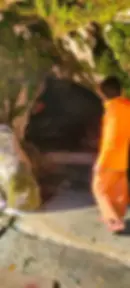 The cave of Koteshwar with a priest going inside