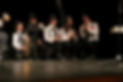 Grup de joves tocant instruments en una banda musical a l'escenari d'Àtic Taller Musical