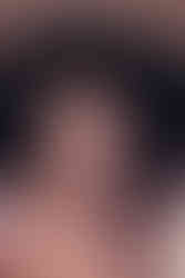 a 70's inspired portrait of anjuli looking smoulderingly at the viewer. her afro picked out and wild almost as if by a wind machine.