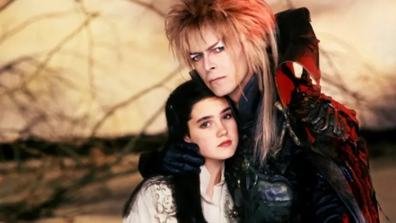 An older man with long hair holding a younger girl who looks scared, from the movie "Labyrinth."