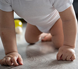 Kinderphysiotherapie suesses baby im niedrigen winkel das auf dem boden kriecht