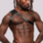 Attractive muscular male wearing high fashion faux leather adjustable shoulder harness