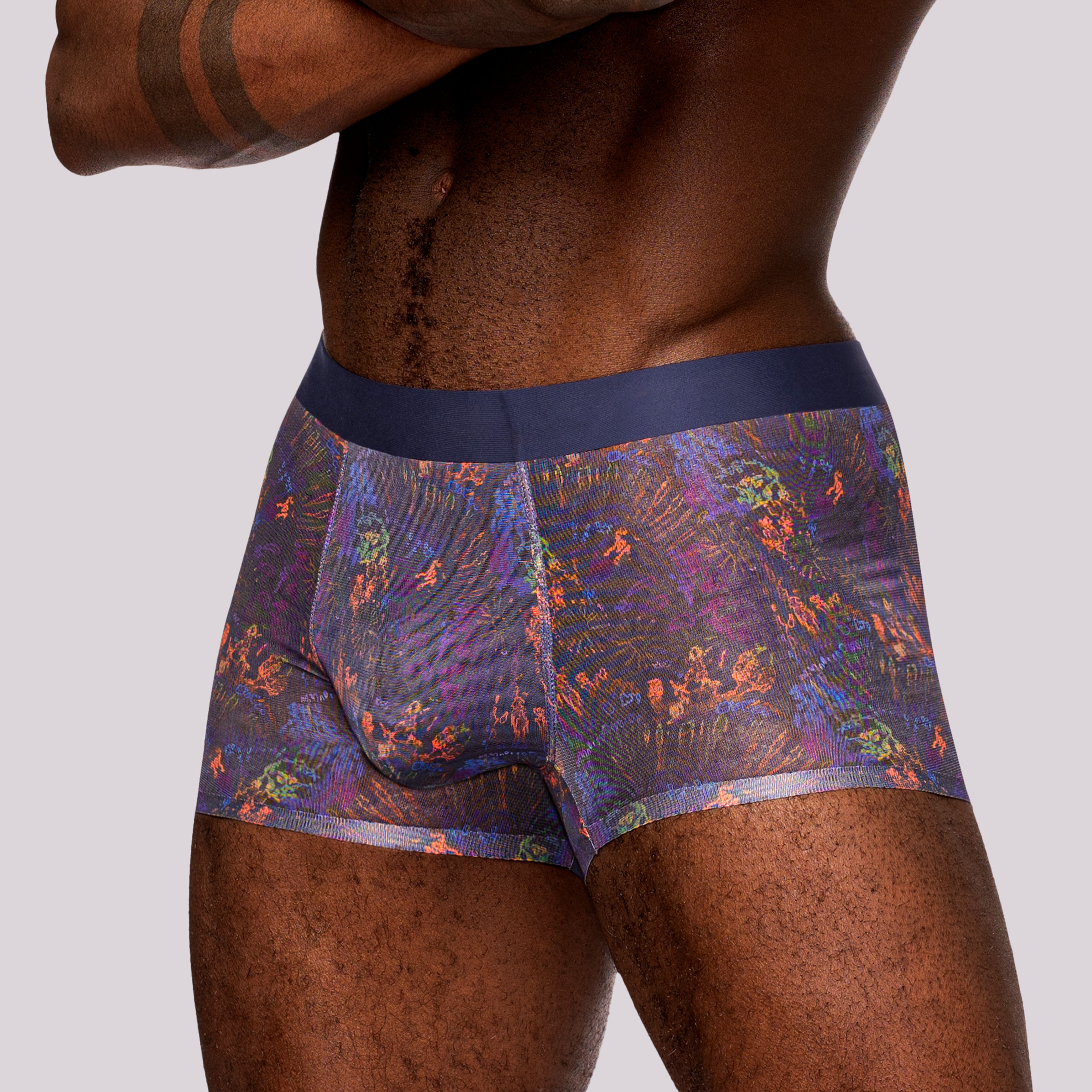 Male model wearing purple splatter paint colorful sheer boxer shorts, side view