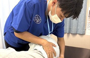 柔道整復師が患者様に施術を行っている場面。