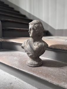 Classical female bust sculpture with aged stone finish.