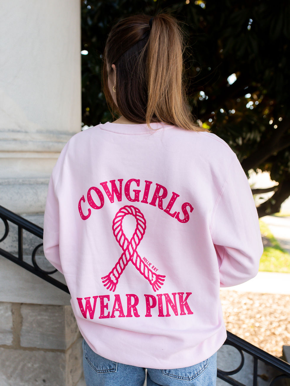 Thumbnail: Model wearing a light pink Cowgirls Wear Pink breast cancer awareness sweatshirt with a bright pink rope ribbon graphic