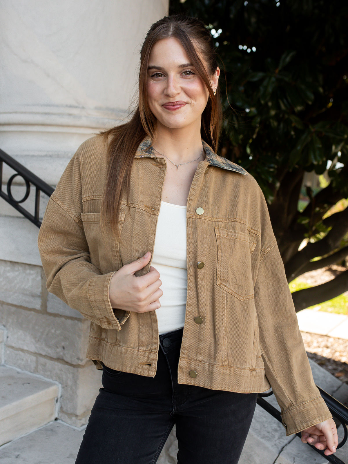 Model wearing the Palmer Plaid Collar Jacket in Camel with washed cotton denim, a contrasting plaid collar, and black jeans.