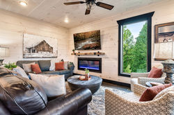 Living room with couches, TV, and electronic fireplace at Serenity Point cabin in Pigeon Forge