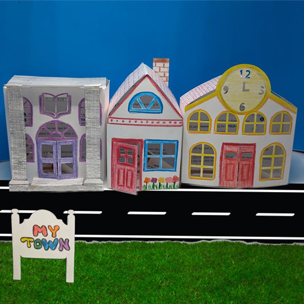 Thumbnail: Photo of the 3 fully assembled STEAM kits, featuring decorated paper buildings and community sign