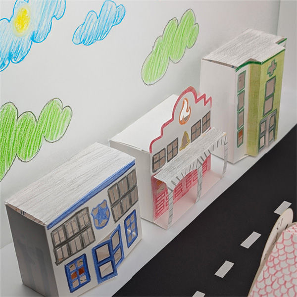 Thumbnail: Photo of the 3 fully assembled STEAM kits, featuring decorated paper buildings with printable street