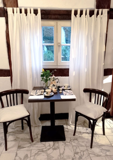 Zwei Stühle mit kleinem, romantisch gedecktem Tisch