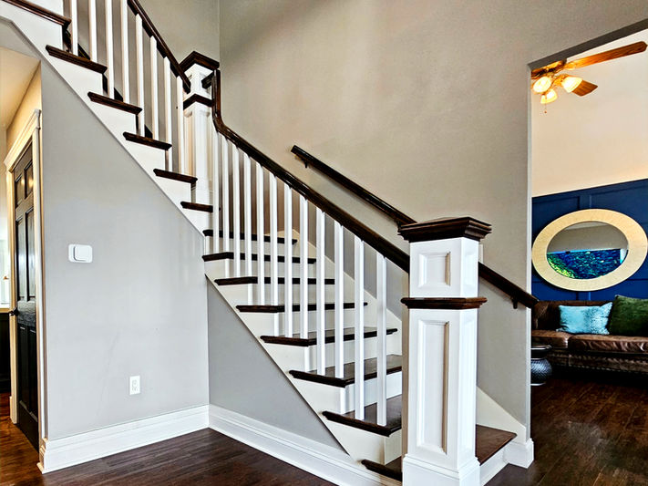 Custom newel posts and a bold king post give this staircase timeless character with refined craftsmanship. 