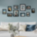 Gallery wall with a collage of black picture frames of different sizes displaying family photos and travel memories, above a white sofa with blue and beige pillows in a cozy living room.