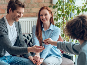 Família sorridente discutindo compra de imóvel em Botucatu, cidade com qualidade de vida e alto potencial de valorização imobiliária.