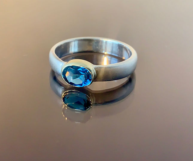 Zilveren ring met gouden zetkast en ovale London Blue topaas