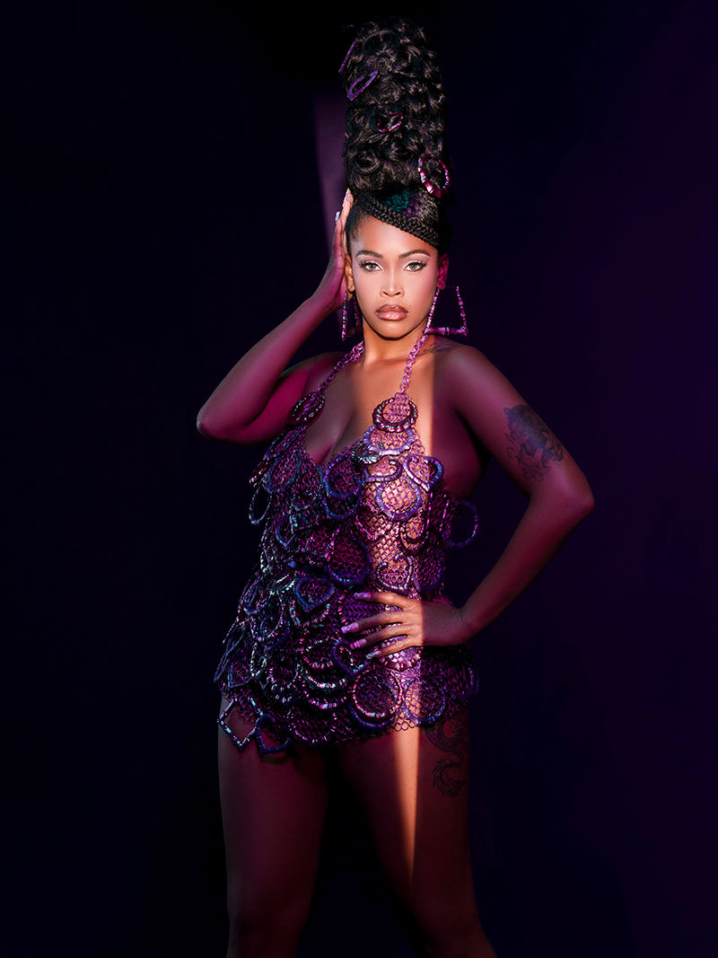 Spotlight on black model with ornamental fishnet outfit and extravagant black hair updo