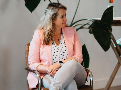 Nicole Bouwer tijdens een workshop, zittend en in gesprek. Een moment van verbinding en rust.