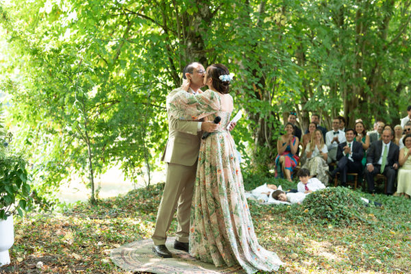 Les mariés s'enlacent au milieu de leurs invités à la fin de la cérémonie laïque en plein air