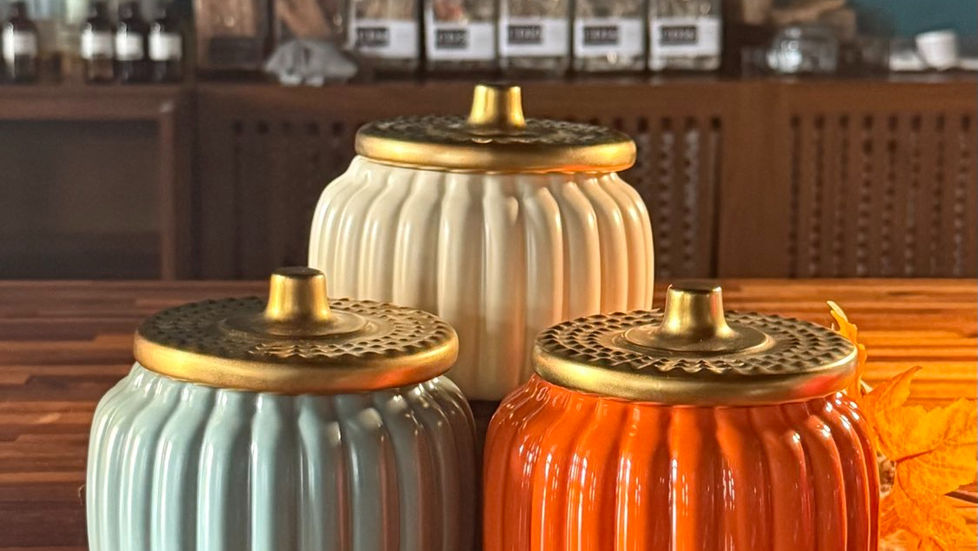 Three ceramic pumpkins on wooden table