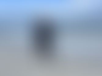 Alexandra Levchuk standing on a beach, looking toward the ocean with waves behind her, symbolizing clarity and focus in product prioritization.