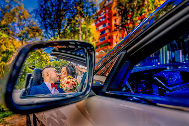 Reflejo en el espejo de novios besándose con ramo de flores, fotografía de bodas.