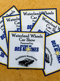 Waterland Wheels car show at Des Moines Marina, featuring classic and modern cars with polished chrome, powerful engines, detailed dashboards, and scenic views of the Puget Sound, complemented by live music, food trucks, and a beer garden