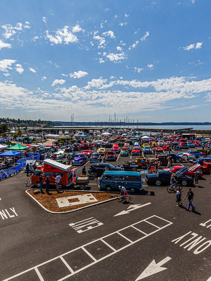 Waterland Wheels car show at Des Moines Marina, featuring classic and modern cars with polished chrome, powerful engines, detailed dashboards, and scenic views of the Puget Sound, complemented by live music, food trucks, and a beer garden