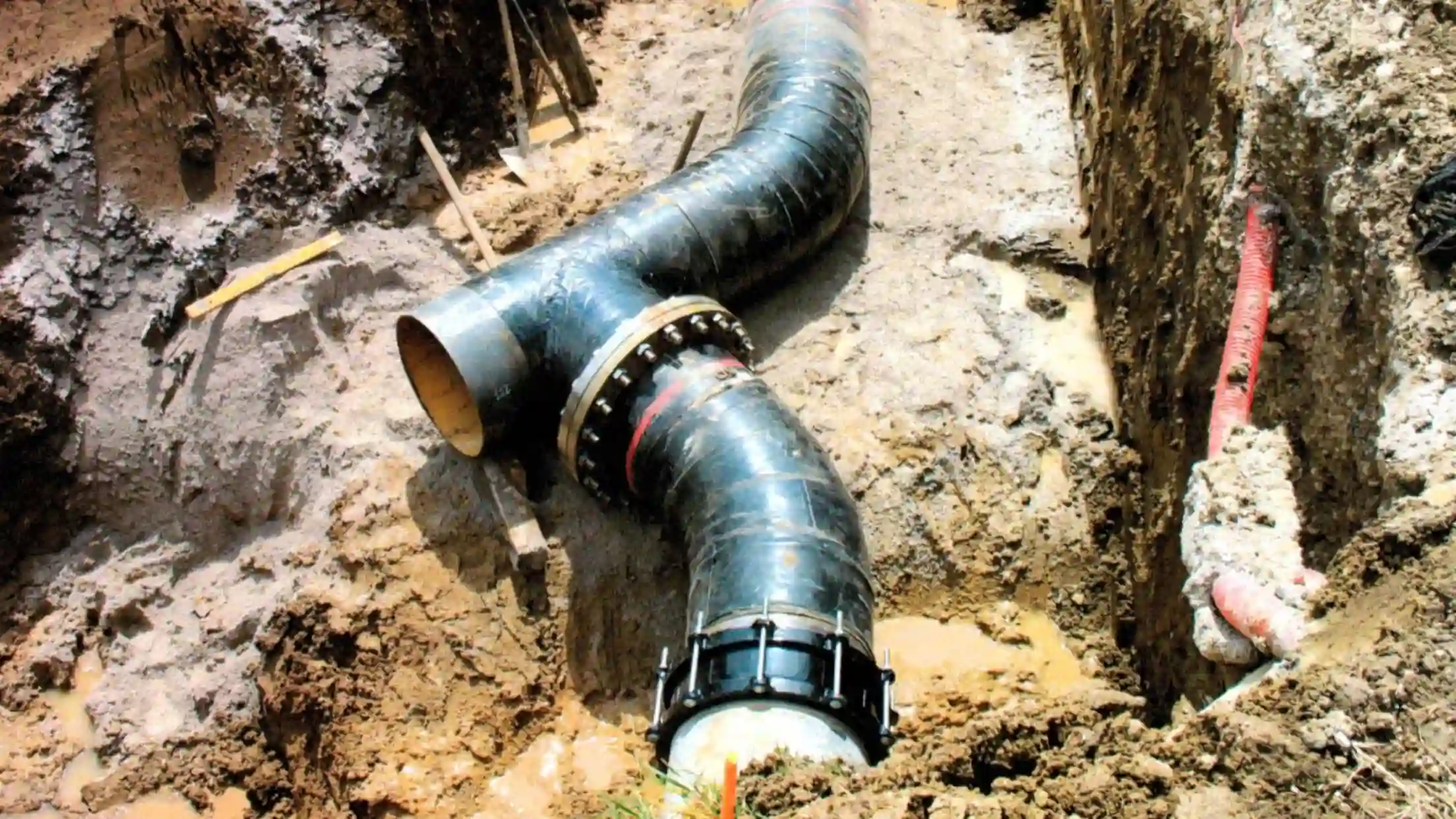 Bolted pipe connections and bends installed in an open trench